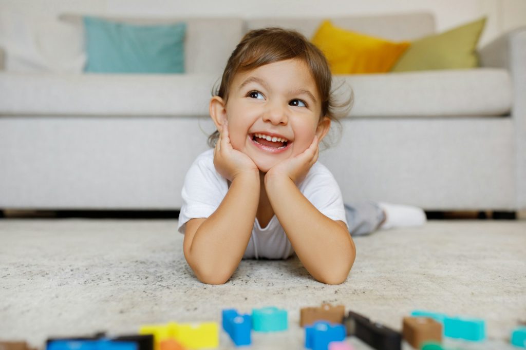 Dreamy Cute Toddler Girl Lying On Floor In Living Room Interior