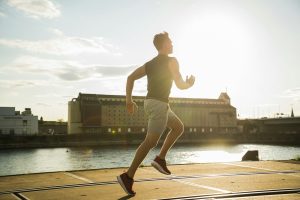 Young man running by the riverside