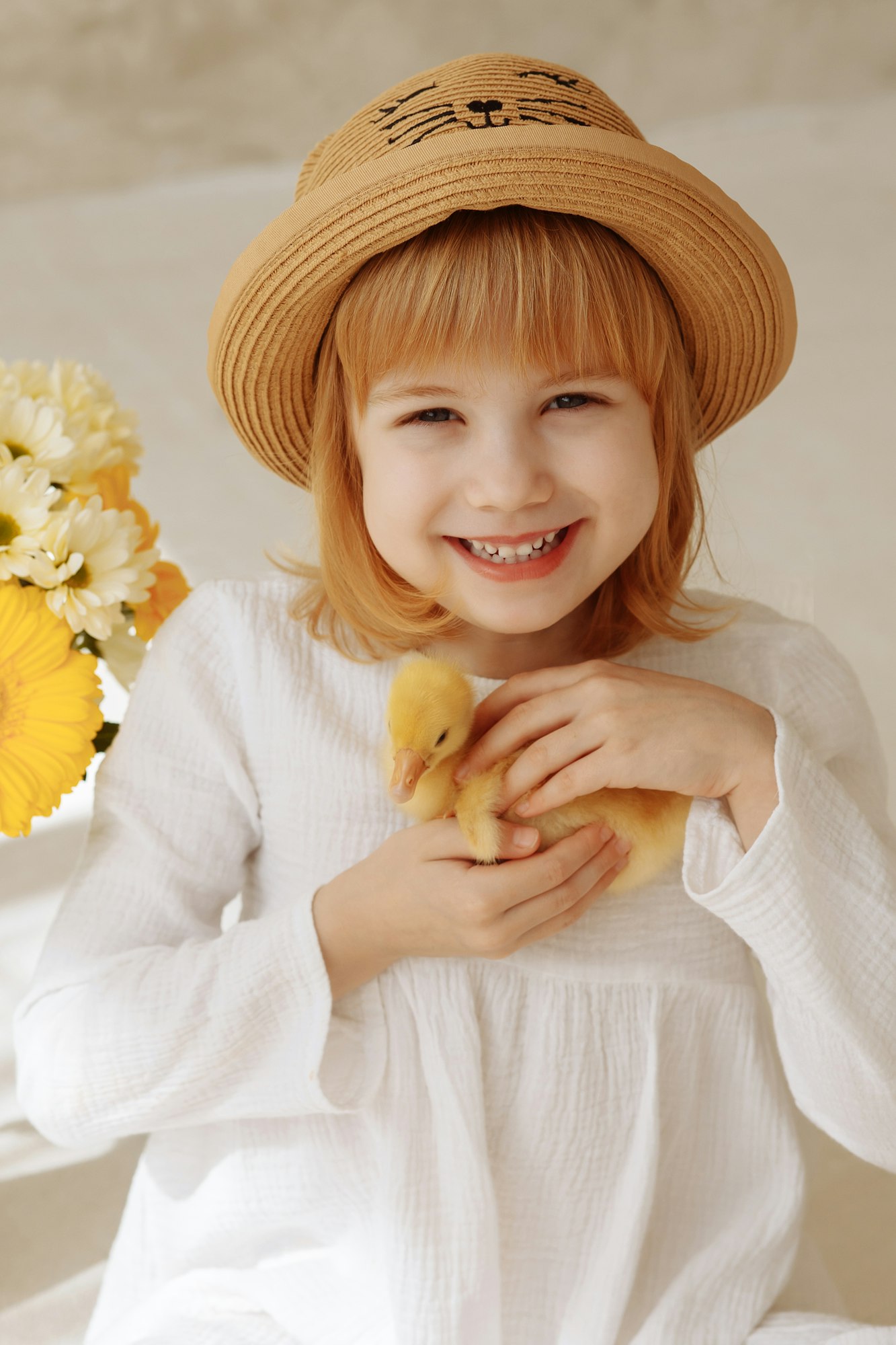 A cheerful child holds a live duck in his hands